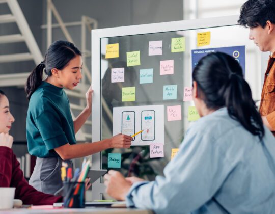 Group of AAPI UX/UI designers working on strategizing app design while working in tech