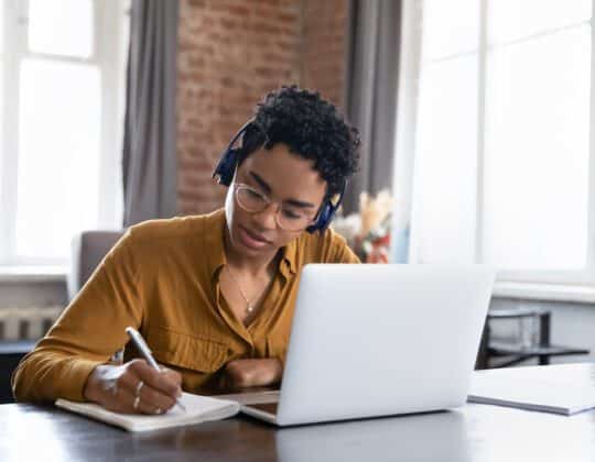 woman actively learning by taking notes on a notepad